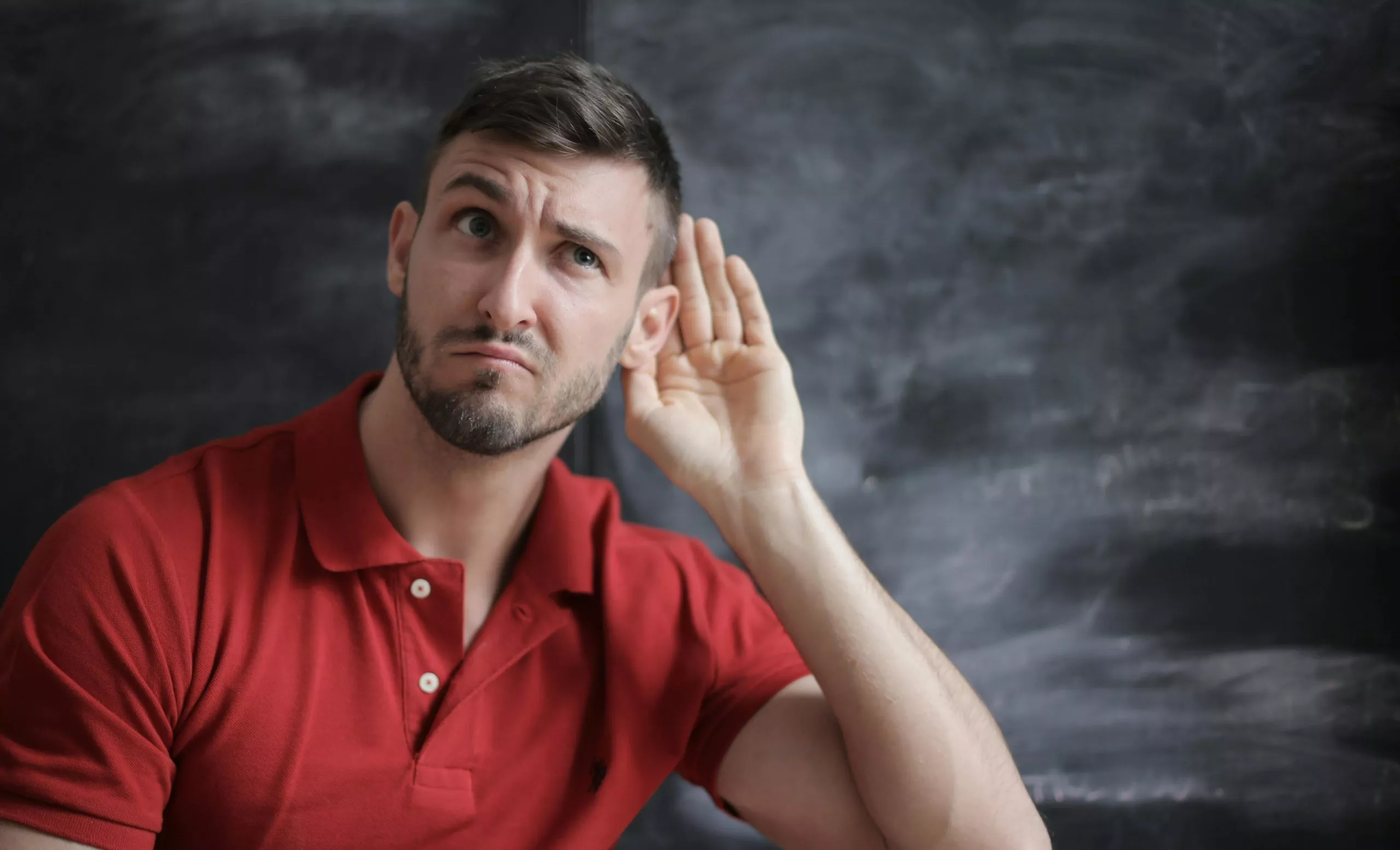 Person with hand to his ear listening in