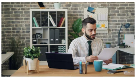 Man reading papers at his desk